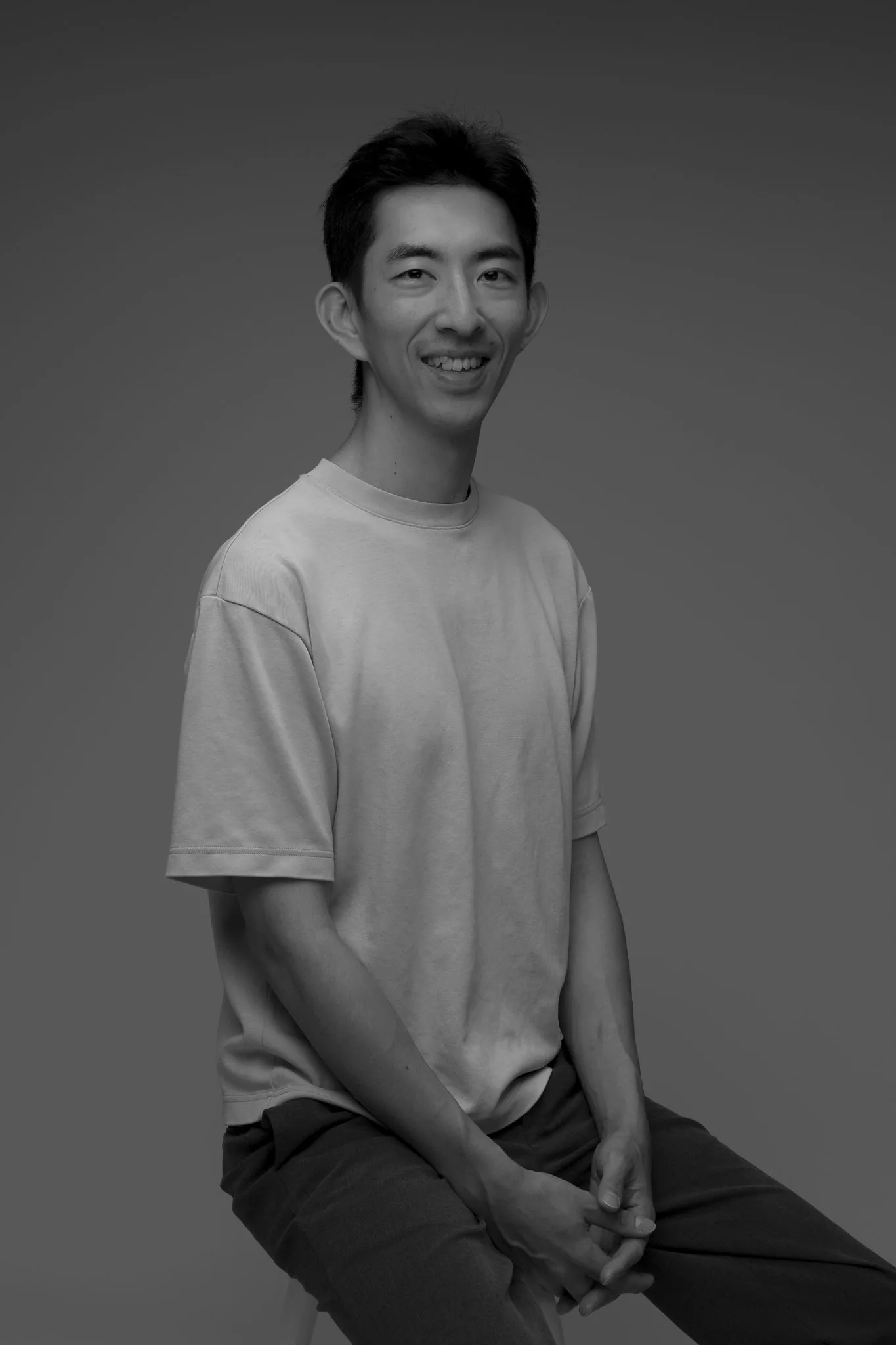 Howard C, Core Instructor, seated black-and-white studio portrait