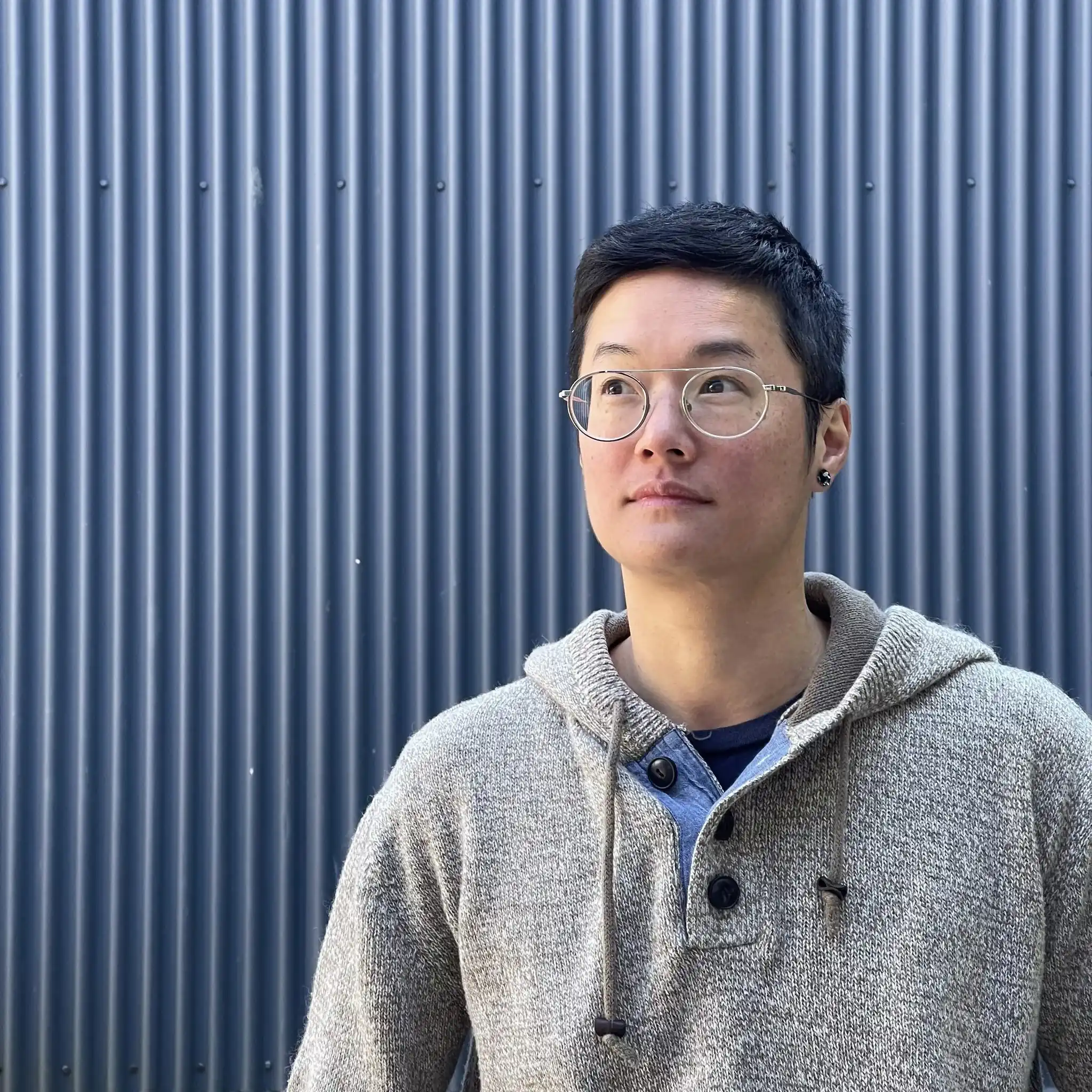 JC F, Creative Technology Instructor, in round glasses and a knit hoodie
